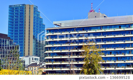 Modern sustainable glass office buildings. Exterior view of corporate headquarters glass buildings architecture.Glass windows in energy-efficient buildings. Financial business center buildings. Modern sustainable glass office buildings. Exterior view of corporate headquarters glass buildings architecture.Glass windows in energy-efficient buildings. Financial business center buildings. 136699528