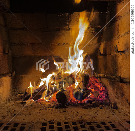 Cozy home fireplace with bright flames and burning logs 136699693