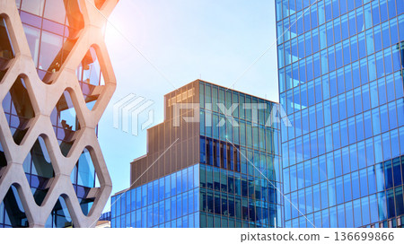 Modern sustainable glass office buildings. Exterior view of corporate headquarters glass buildings architecture.Glass windows in energy-efficient buildings. Financial business center buildings. Modern sustainable glass office buildings. Exterior view of corporate headquarters glass buildings architecture.Glass windows in energy-efficient buildings. Financial business center buildings. 136699866