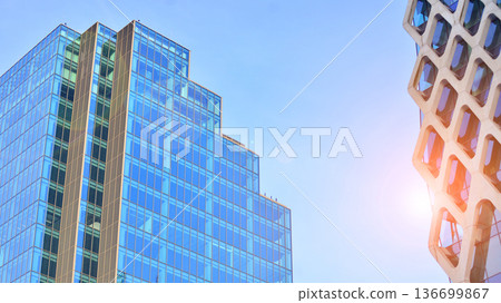 Modern sustainable glass office buildings. Exterior view of corporate headquarters glass buildings architecture.Glass windows in energy-efficient buildings. Financial business center buildings. Modern sustainable glass office buildings. Exterior view of corporate headquarters glass buildings architecture.Glass windows in energy-efficient buildings. Financial business center buildings. 136699867