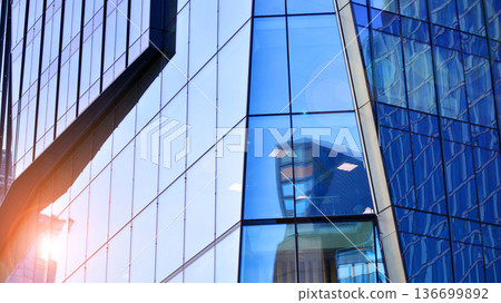 Modern sustainable glass office buildings. Exterior view of corporate headquarters glass buildings architecture.Glass windows in energy-efficient buildings. Financial business center buildings. Modern sustainable glass office buildings. Exterior view of corporate headquarters glass buildings architecture.Glass windows in energy-efficient buildings. Financial business center buildings. 136699892