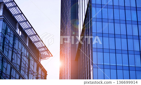 Modern sustainable glass office buildings. Exterior view of corporate headquarters glass buildings architecture.Glass windows in energy-efficient buildings. Financial business center buildings. Modern sustainable glass office buildings. Exterior view of corporate headquarters glass buildings architecture.Glass windows in energy-efficient buildings. Financial business center buildings. 136699914