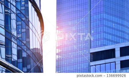 Modern sustainable glass office buildings. Exterior view of corporate headquarters glass buildings architecture.Glass windows in energy-efficient buildings. Financial business center buildings.  136699926