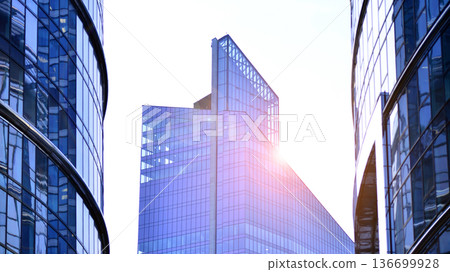 Modern sustainable glass office buildings. Exterior view of corporate headquarters glass buildings architecture.Glass windows in energy-efficient buildings. Financial business center buildings. Modern sustainable glass office buildings. Exterior view of corporate headquarters glass buildings architecture.Glass windows in energy-efficient buildings. Financial business center buildings. 136699928