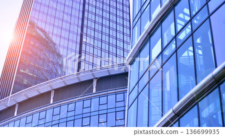 Modern sustainable glass office buildings. Exterior view of corporate headquarters glass buildings architecture.Glass windows in energy-efficient buildings. Financial business center buildings. Modern sustainable glass office buildings. Exterior view of corporate headquarters glass buildings architecture.Glass windows in energy-efficient buildings. Financial business center buildings. 136699935