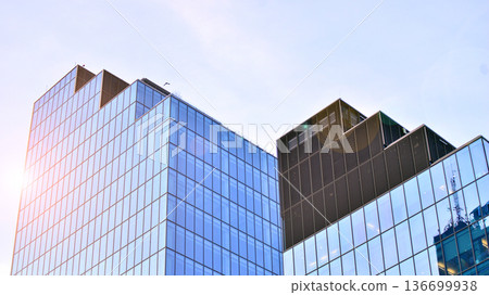 Modern sustainable glass office buildings. Exterior view of corporate headquarters glass buildings architecture.Glass windows in energy-efficient buildings. Financial business center buildings. Modern sustainable glass office buildings. Exterior view of corporate headquarters glass buildings architecture.Glass windows in energy-efficient buildings. Financial business center buildings. 136699938