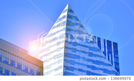 Exterior view of corporate headquarters glass buildings architecture. Modern sustainable glass office buildings. Glass windows in energy-efficient buildings. Financial business center buildings. Exterior view of corporate headquarters glass buildings architecture. Modern sustainable glass office buildings. Glass windows in energy-efficient buildings. Financial business center buildings. 136699978