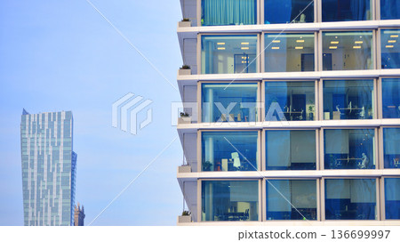 Exterior view of corporate headquarters glass buildings architecture. Modern sustainable glass office buildings. Glass windows in energy-efficient buildings. Financial business center buildings. Exterior view of corporate headquarters glass buildings architecture. Modern sustainable glass office buildings. Glass windows in energy-efficient buildings. Financial business center buildings. 136699997