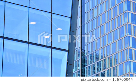 Exterior view of corporate headquarters glass buildings architecture. Modern sustainable glass office buildings. Glass windows in energy-efficient buildings. Financial business center buildings.  136700044