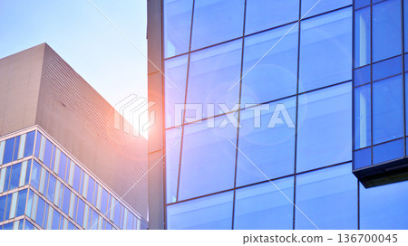 Exterior view of corporate headquarters glass buildings architecture. Modern sustainable glass office buildings. Glass windows in energy-efficient buildings. Financial business center buildings.  136700045