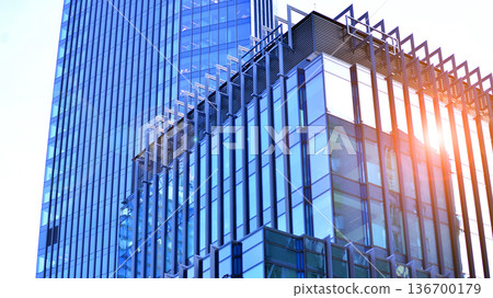 Exterior view of corporate headquarters glass buildings architecture. Modern sustainable glass office buildings. Glass windows in energy-efficient buildings. Financial business center buildings.  136700179