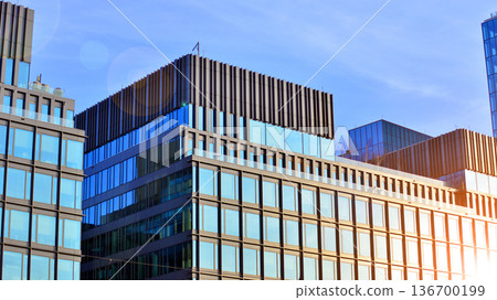 Exterior view of corporate headquarters glass buildings architecture. Modern sustainable glass office buildings. Glass windows in energy-efficient buildings. Financial business center buildings.  136700199