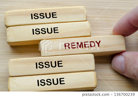 Issue and Remedy text on wooden blocks representing identifying issues and applying practical remedies for improvement 136700239