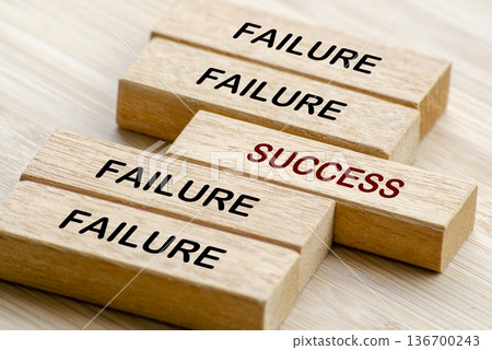 Failure and Success text on wooden blocks representing turning setbacks into success through persistence and strategy 136700243