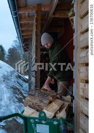 Winter Firewood Preparation by Rustic Wooden Cabin. Winter Firewood Preparation by Rustic Wooden Cabin. 136700616