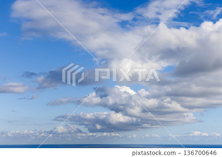 Soft natural light and airy clouds over a far ocean horizon form versatile backdrop for design work 136700646