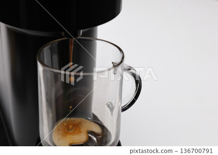 Brewing coffee into a mug using a coffee maker Brewing coffee into a mug using a coffee maker 136700791