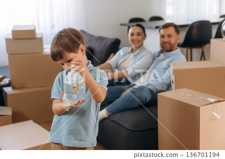Child is standing and holding fish. Family of husband, wife and son are moving into new house Child is standing and holding fish. Family of husband, wife and son are moving into new house 136701194