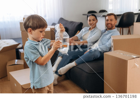 Looking at fish. Family of husband, wife and son are moving into new house Looking at fish. Family of husband, wife and son are moving into new house 136701198