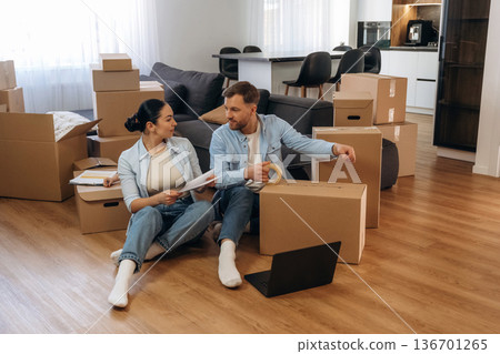 Using scotch to pack the box. Happy couple moved into new house 136701265