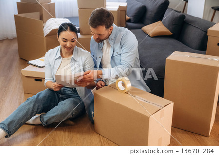 How to pack the box using scotch tape. Happy couple moved into new house How to pack the box using scotch tape. Happy couple moved into new house 136701284