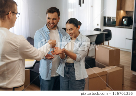 Receiving keys. Couple are buying new house with the help of manager 136701336
