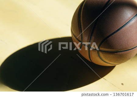 Close up view of basketball ball that is on the ground indoors under sunlight Close up view of basketball ball that is on the ground indoors under sunlight 136701617