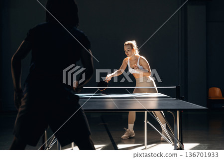 Tennis game, man and woman are indoors Tennis game, man and woman are indoors 136701933