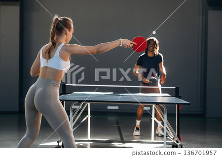 Bouncing the ball. Tennis game, man and woman are indoors Bouncing the ball. Tennis game, man and woman are indoors 136701957