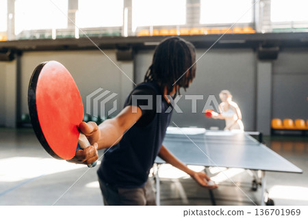 Bouncing the ball. Tennis game, man and woman are indoors 136701969