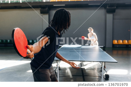Bouncing the ball. Tennis game, man and woman are indoors Bouncing the ball. Tennis game, man and woman are indoors 136701970
