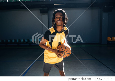 Playing basketball. Young black man is indoors 136702208