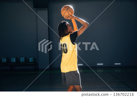 About to throw the ball. Young black man is playing basketball indoors About to throw the ball. Young black man is playing basketball indoors 136702218