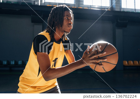 One person only. Young black man is playing basketball indoors One person only. Young black man is playing basketball indoors 136702224