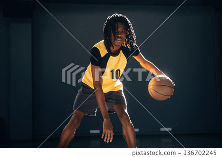 Player number ten. Young black man is playing basketball indoors Player number ten. Young black man is playing basketball indoors 136702245