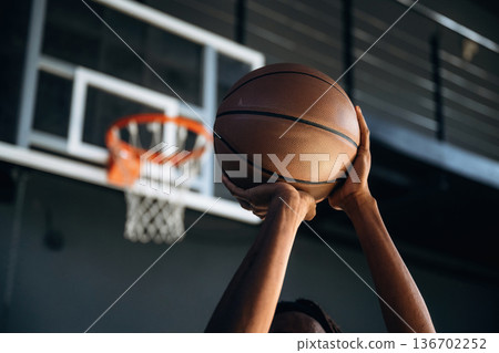 Close up view of man's hands that are about to throw basketball ball into the hoop 136702252