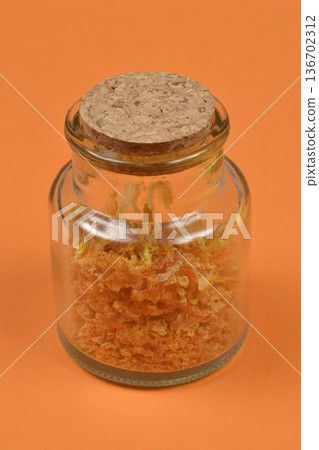 Dried orange peel in a small glass jar with cork Dried orange peel in a small glass jar with cork 136702312