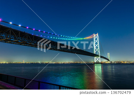明石海峽大橋和大海的夜景呈現出彩虹般的色彩。 明石海峽大橋和大海的夜景呈現出彩虹般的色彩。 136702479