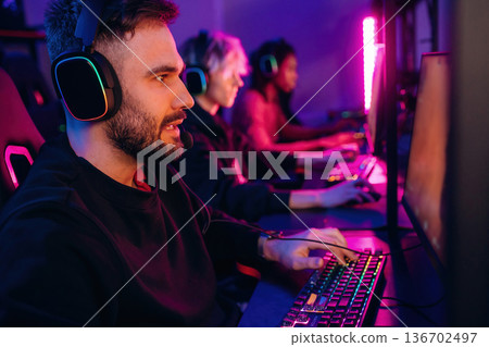 In headphones. Gamers are playing video game by computers 136702497