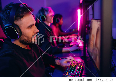 In headphones. Gamers are playing video game by computers 136702498