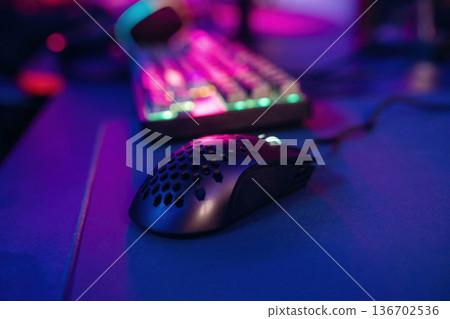 Colorful keyboard. Gaming computer is in the dark room with neon lighting Colorful keyboard. Gaming computer is in the dark room with neon lighting 136702536