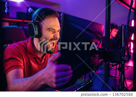 Man is mad, screaming, angry. Gamers are playing video game by computers Man is mad, screaming, angry. Gamers are playing video game by computers 136702588