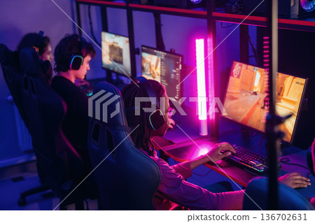 Sitting and focused. Gamers are playing video game by computers Sitting and focused. Gamers are playing video game by computers 136702631