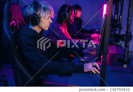 High end PC's, side view. Gamers are playing video game by computers High end PC's, side view. Gamers are playing video game by computers 136702632