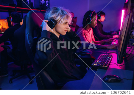 High end PC's, side view. Gamers are playing video game by computers High end PC's, side view. Gamers are playing video game by computers 136702641