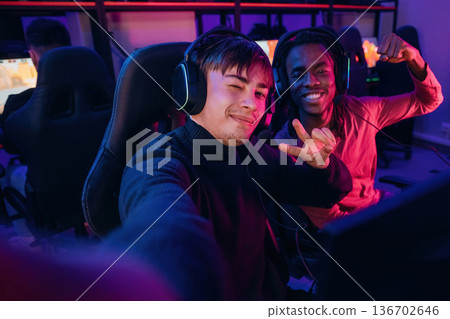 Facial expression, making selfie. Gamers are playing video game by computers 136702646