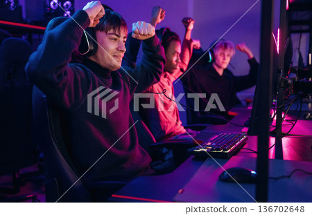Celebrating victory. Gamers are playing video game by computers 136702648