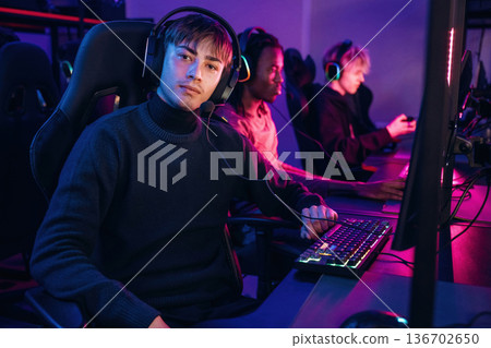 Neon colors in the room. Gamers are playing video game by computers 136702650