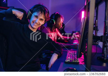 Gamers are playing video game by computers Gamers are playing video game by computers 136702660