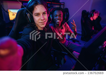 Selfie time. Gamers are playing video game by computers Selfie time. Gamers are playing video game by computers 136702669
